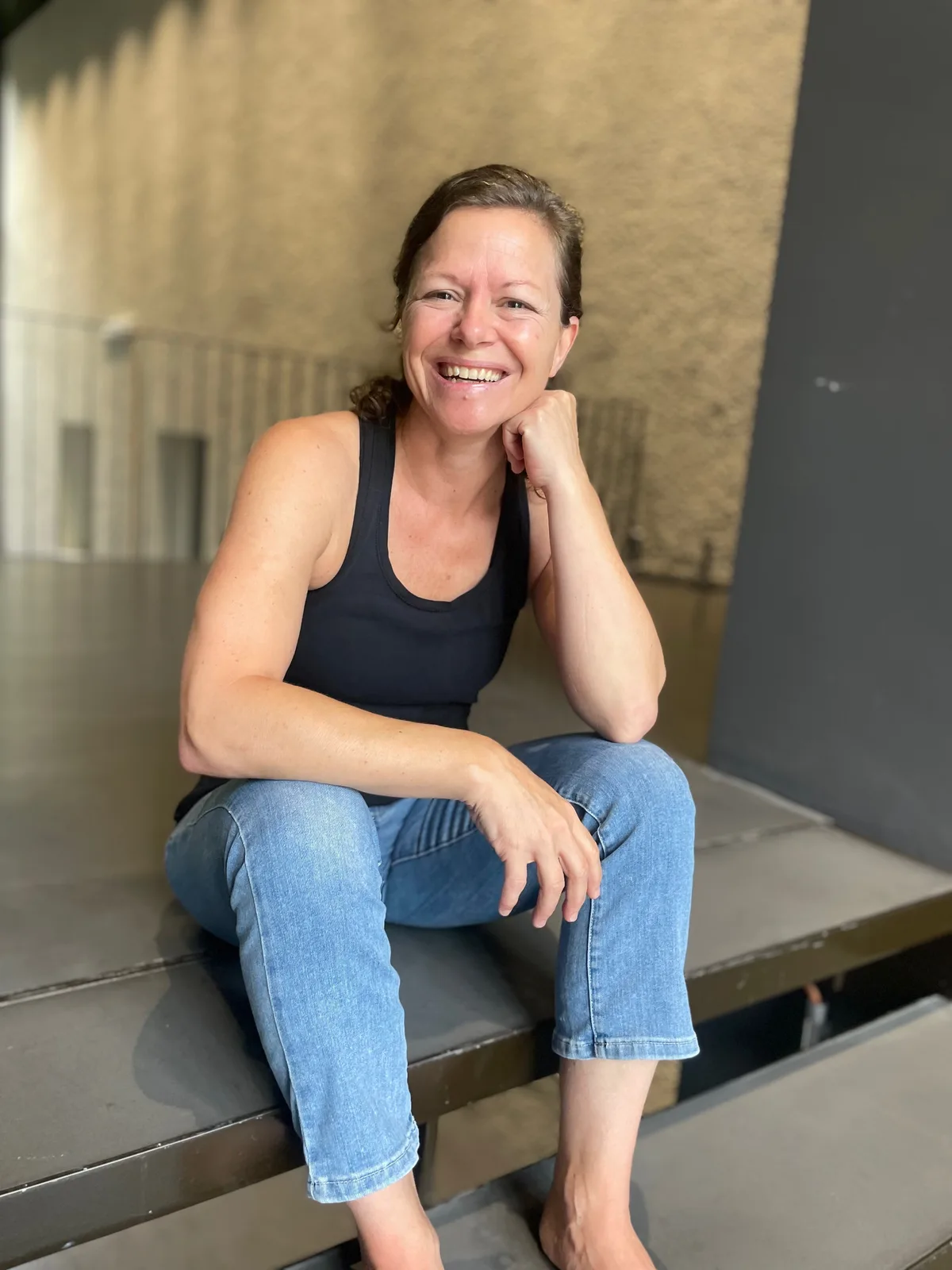 Daniela Küng sitzt auf dem Boden und lacht in die Kamera.